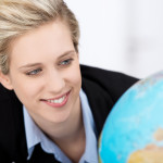 Junge Studentin schaut auf einen Globus